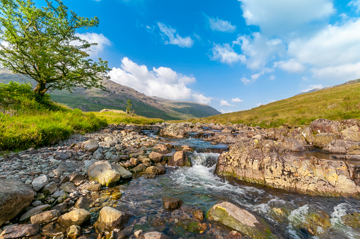 River cascading down a rocky riverbed high in the English Lake District mountains 