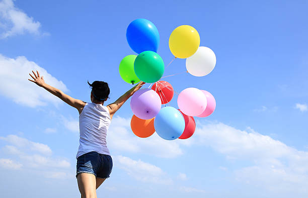 istock young asian woman running with colored balloons 503025608