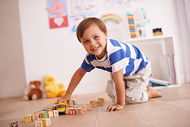 Learning through play Portrait of a cute little boy playing with his building blocks and toys in his room kid toy car stock pictures, royalty-free photos & images