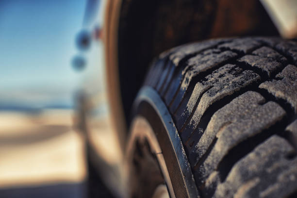 These tyres eat up any terrain Shot of a heavy duty 4x4 driving along some sand dunes tire vehicle part photos stock pictures, royalty-free photos & images
