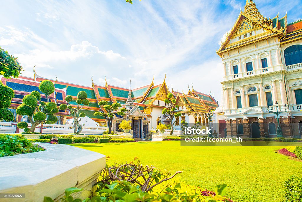 Grand Palace and Wat Phra Kaew Temple Chakri Maha Prasat Throne Hall at the Grand Palace same area with Wat Phra Kaeo, Bangkok, Thailand. The Emerald Buddha temple. Dramatic sunset cloudscape with blue sky and orange clouds over the Grand Palace. Architecture Stock Photo