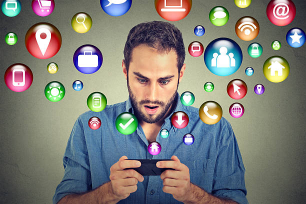 istock Shocked man texting on smartphone application icons flying out 503029292
