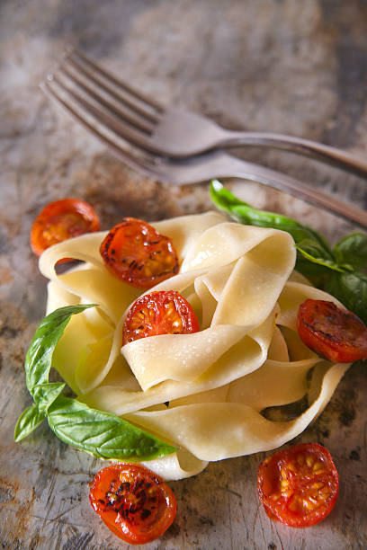 Nest of pappardelle pasta with tomato and basil