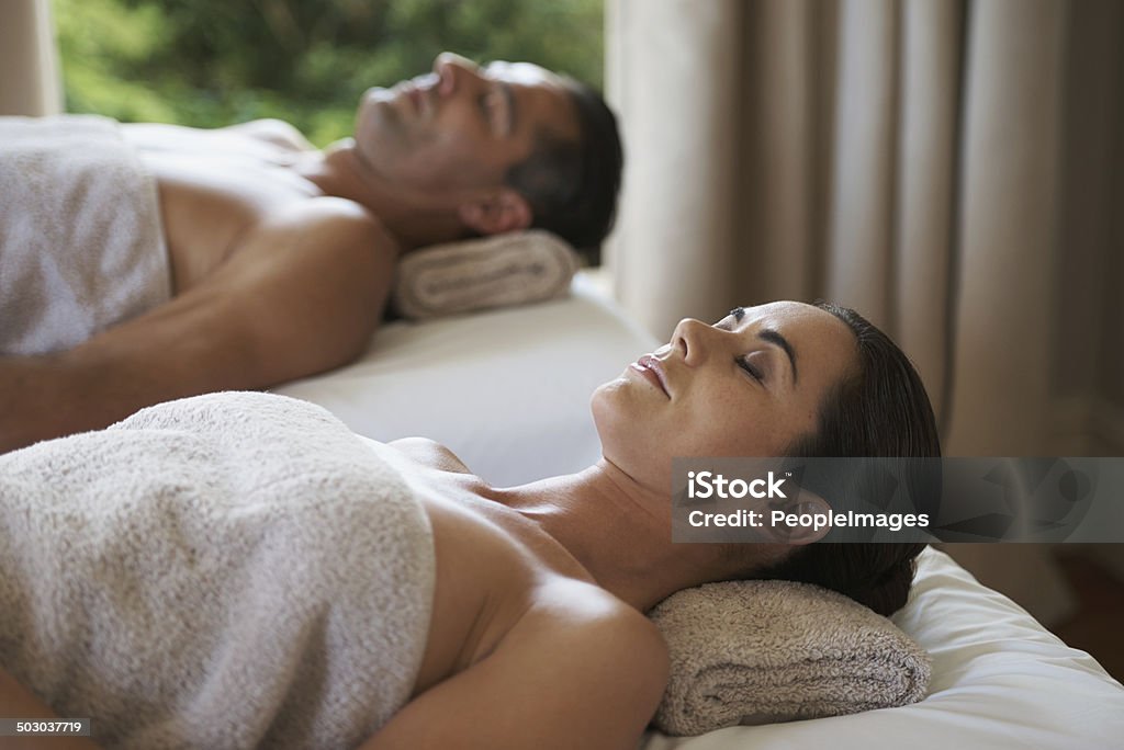 Indulging in the simple pleasure of peace Shot of a mature couple relaxing on their massage tables Adult Stock Photo