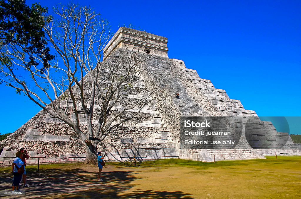 Kukulcan pyramid behind the dry tree Chichen Itzá, Yucatán, México – January 10, 2008: Kukulcan pyramid in archaeological site of Chichen Itza with tourists around Ancient Stock Photo