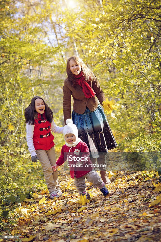 Family of in autumn park Young mother with their daughtes outdoors in autumn park Activity Stock Photo