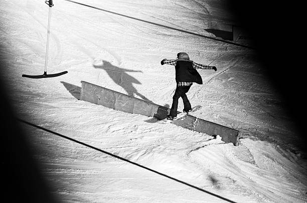 young snowboarder sliding on rail stock photo