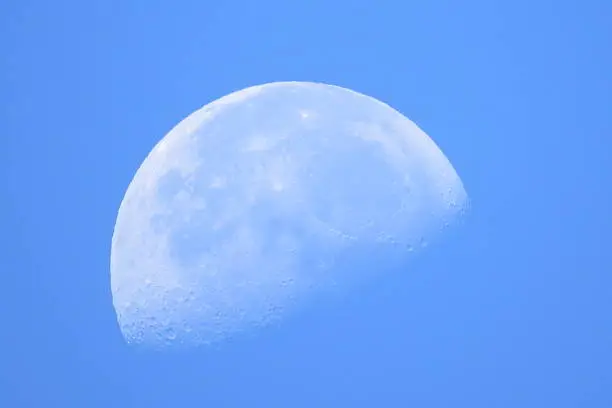 A bright moon in the clear blue sky