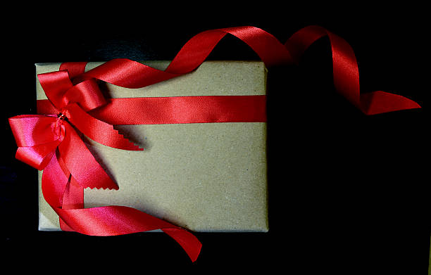 istock Vintage gift with red bow on black wooden background 503052164