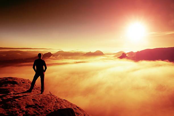 istock Hiker in black stands on rock abve valley within daybreak 503054506