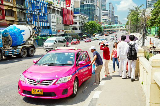 Bangkok, Thailand- April 29, 2015:  Pedestrians stopped a taxi in Bangkok. There are 150,000 taxis in Bangkok. All are metered with the starting fee of 35 Baht for the first 3 kilometers.