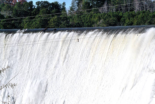 istock High water flowing over dam with power lines in foreground 503059236