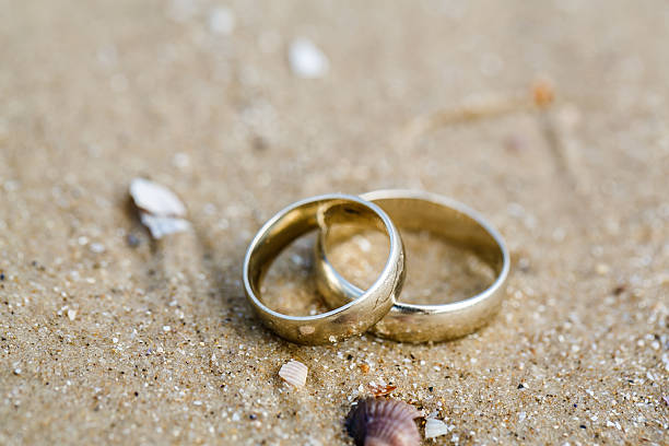istock Wedding concept - wedding rings lie on sand 503059530