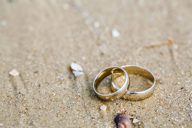 istock Wedding concept - wedding rings lie on sand 503059556