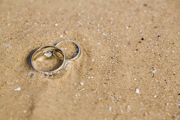 istock Wedding concept - wedding rings lie on sand 503059652