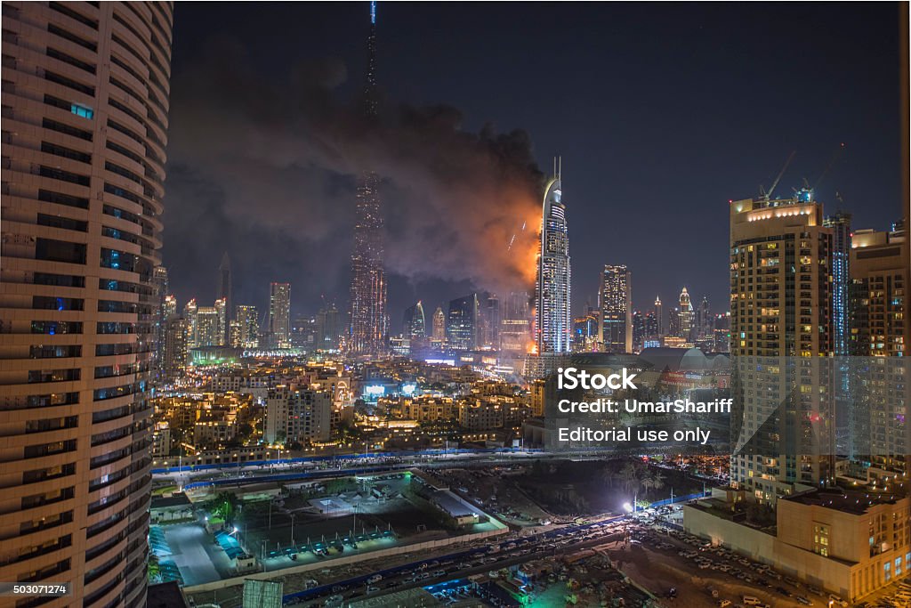 Dubai Burj Khalifa New Year fireworks 2016 Dubai, United Arab Emirates - January 1, 2016: Dubai Burj Khalifa New Year fireworks celebration had been carried out despite the fire on The Address Hotel (R) on Januar 1,2016 in Dubai, UAE Emirates Airline Stock Photo