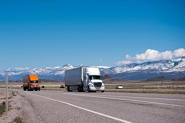 istock White and orange semi trucks and trailers on high way 503075467