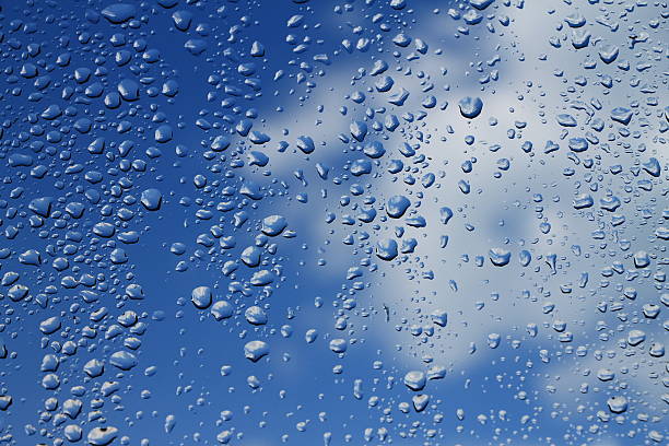 istock Rain drops on window with blue cloudy sky in background 503078306