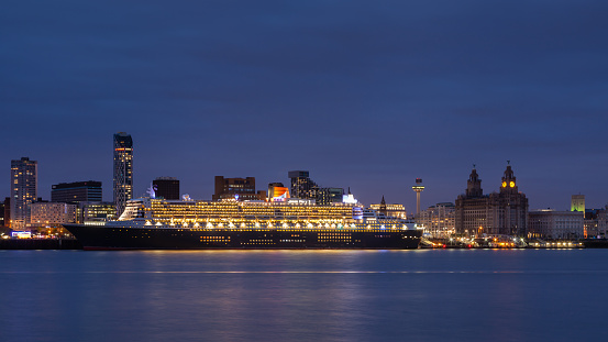 Liverpool, England - May 24, 2015: Cunard cruise liner Queen Mary 2 docked in Liverpool and pictured at dusk as part of celebrations to mark Cunard's 175th anniversary.