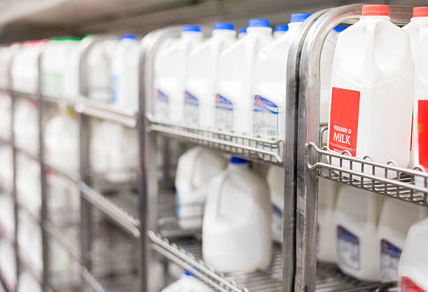 shelves of refrigerated milk in store rows of milk selection in grocery store filling frame. gallon stock pictures, royalty-free photos & images