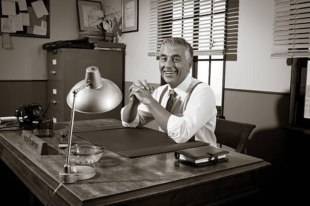 istock Smiling vintage director sitting at office desk 503082796
