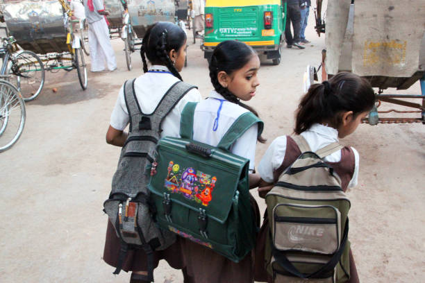 Varanasi, India - March 13, 2011: A group of schoolgirls walk along a street in Varanasi with their backpacks, heading for morning classes.