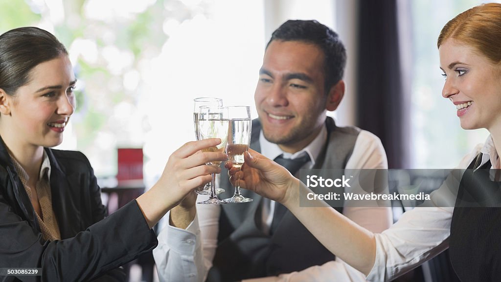 Smiling business people celebrating with champagne Smiling business people celebrating with champagne in a restaurant 20-29 Years Stock Photo