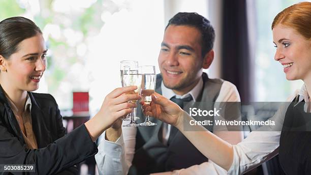 Smiling Business People Celebrating With Champagne Stock Photo - Download Image Now - 20-29 Years, Adult, Alcohol - Drink