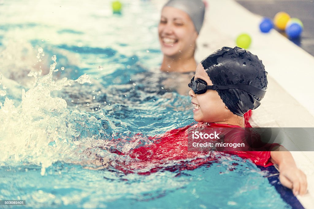 Swimming pool fun Happy little boy having fun in the pool. Toned image Indoors Stock Photo