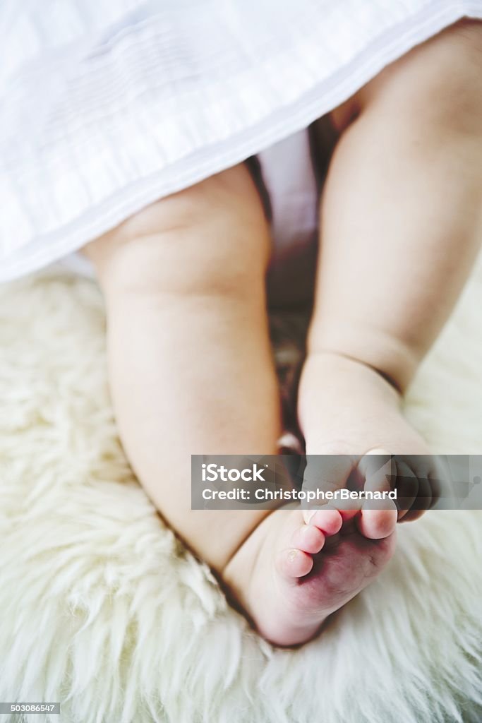 Low section of baby girl on rug. Close up of cute little baby girl's legs on rug. 18-23 Months Stock Photo