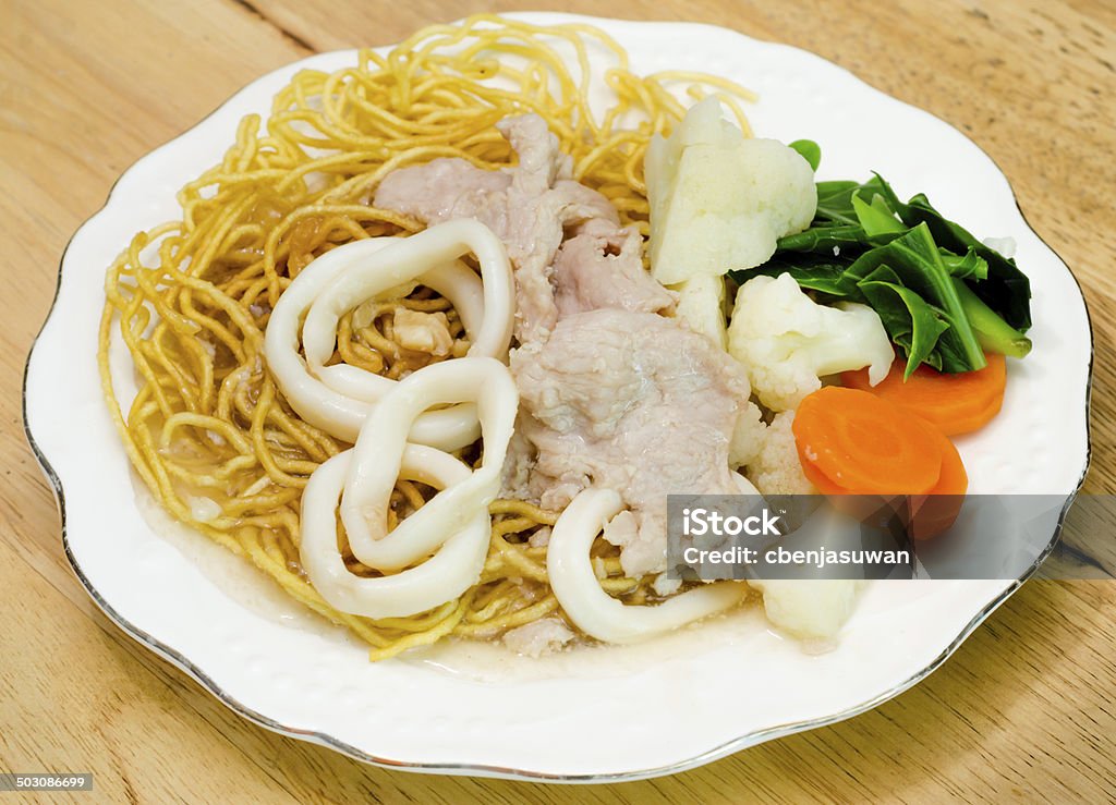 Crispy fried egg noodle with pork and squid Crispy fried egg noodle with pork and squid and kale soaked in gravy Asia Stock Photo