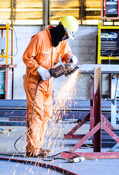 istock Construction: Man Grinding in workshop wearing hardhat and gloves. Sparks 503095749