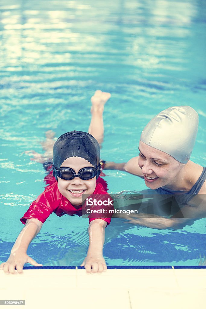 Swimming class in indoor swimming pool Lifftle child having individual swimming class in indoor swimming pool Activity Stock Photo
