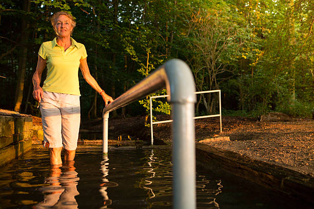 senior woman taking a kneipp cur in a water basin
