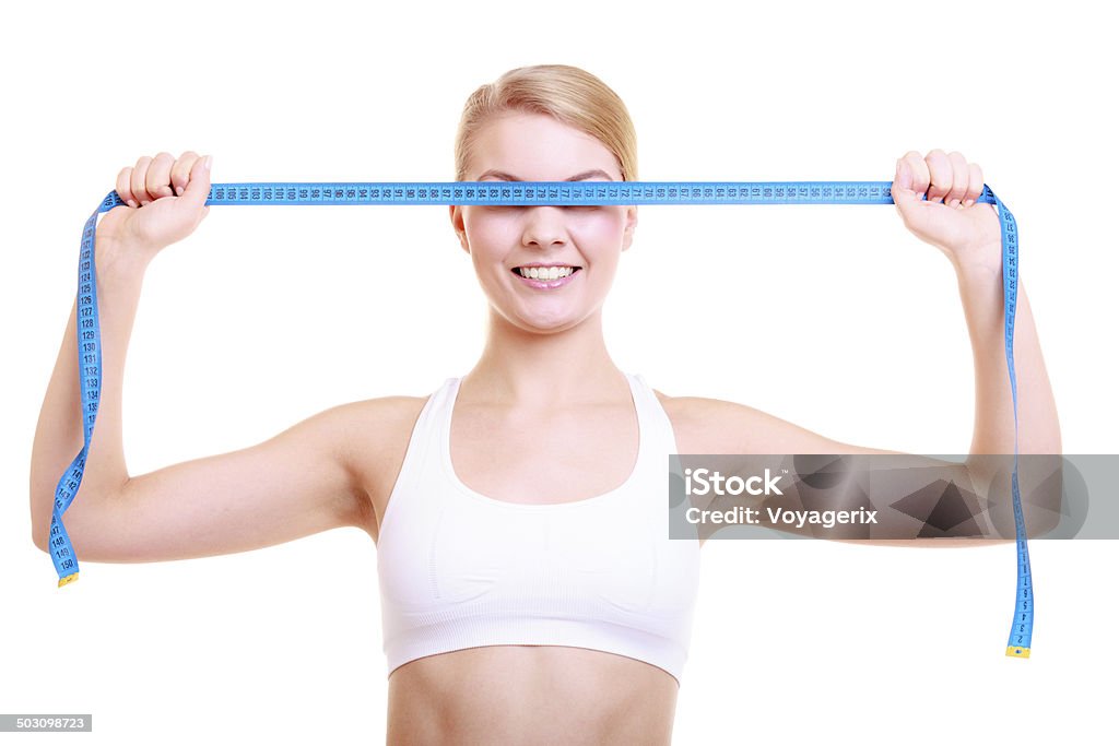 Fitness girl fit woman covering her eyes with measuring tape Body care diet and weight loss concept. Fitness girl sporty woman covering her eyes with measuring tape isolated on white Adult Stock Photo