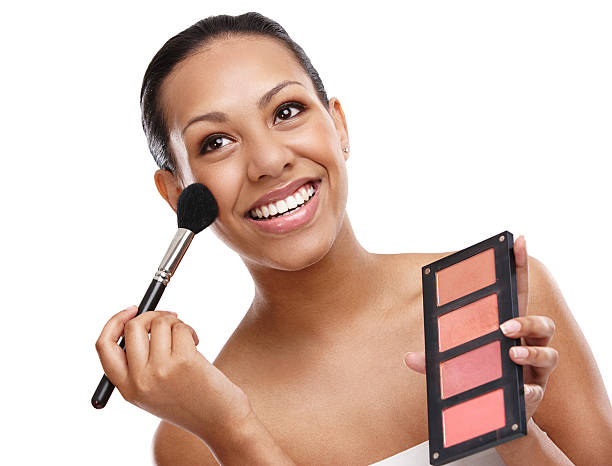 Cropped shot of a beautiful young woman applying blush to her face while standing in studio-isolated on white
