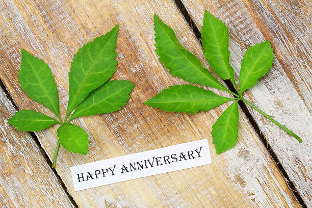 istock Happy Anniversary card with green leaves on rustic wooden surface 503106676