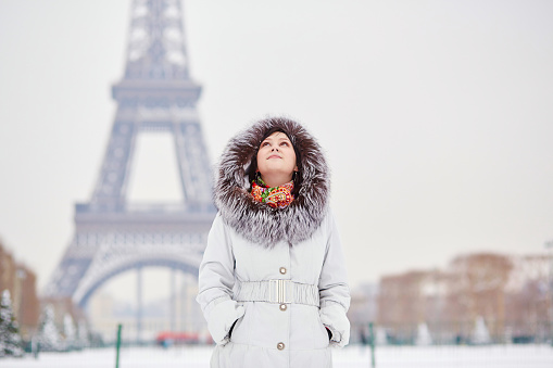 Beautiul young woman enjoying rare snowy winter day in Paris