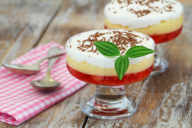 Traditional English strawberry trifle in transparent dessert glass Traditional English strawberry trifle in transparent dessert glass on rustic wooden surface trifle stock pictures, royalty-free photos & images