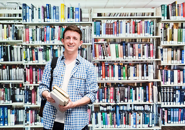 istock Smiling male student in library 503110884