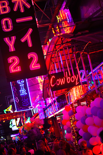 Bangkok, Thailand - December 31, 2015: New years shot in redlight street Soi Cowboy in Bangkok. View along bars decoraed with balloons. In bottom area are some people., bar girls and tourists,