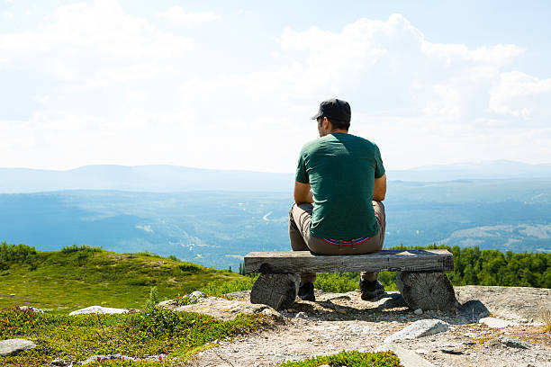 istock Lonely man sitting on mountain top 503112453