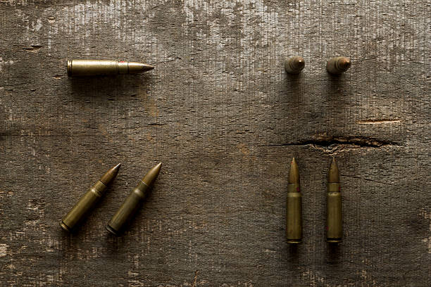 Arranged AK47 rifle bullets on old wooden plank. Directly above view. Photo is taken with dslr camera in studio.