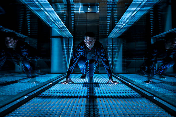special agent crawling in a dark corridor At night a mature man (maybe a special agent or a technician) is crawling on the floor of a corridor with an elevator in the background. He is wearing a blue jean and a shirt with long sleeves and he is looking concentrated at the camera. He is in a starting position with his hands down at the floor. stealth stock pictures, royalty-free photos & images