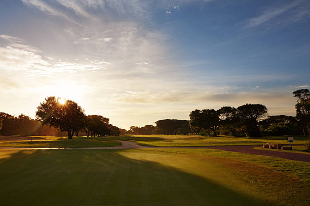 die sonne geht über einen schönen tag auf dem golfplatz - golf golf course sunrise morning stock-fotos und bilder