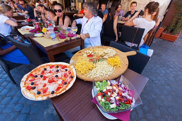 Tourists having food on a street restaurant Rome Italy stock photo