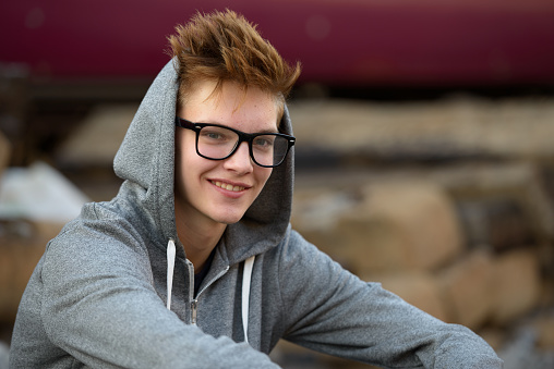 Caucasian teenager boy smiling outdoors at train station