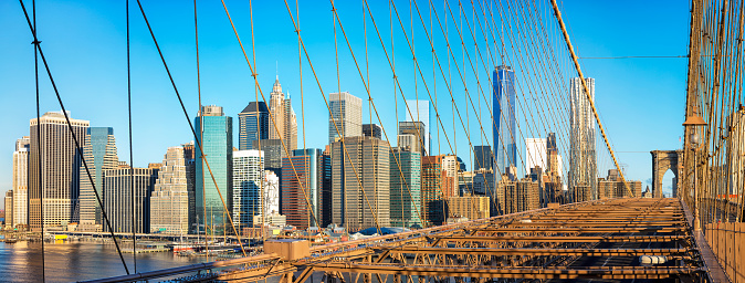 Panorama of Lower Manhattan from Brooklyn Bridge. In the background is seen One World Trade Center - Freedom Tower and Beekman Tower on the right side, the tallest residential tower in world, designed by Frank Gehry. New York City, horizontally stitched composition, America, USA.