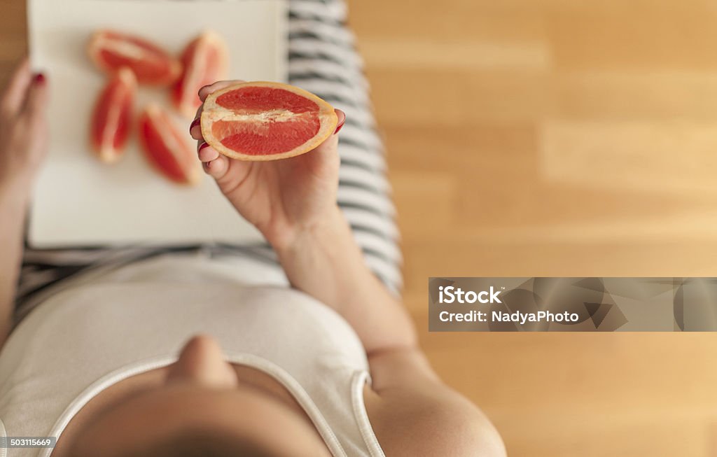 Grapefruit Woman eating grapefruit. Above Stock Photo