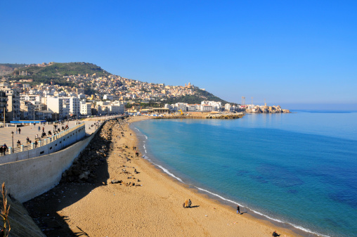 Algiers, Algeria: Rmila / Nelson beach in Bab El Oued, with Notre Dame d'Afrique cathedral and Z'ghara and Bologhine quarters in the background - golden sand by the Mediterranean sea - photo by M.Torres